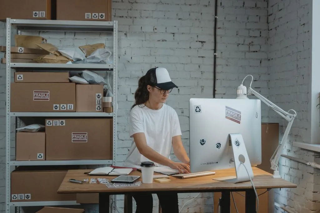 A girl using silver Macbook to fulfill orders